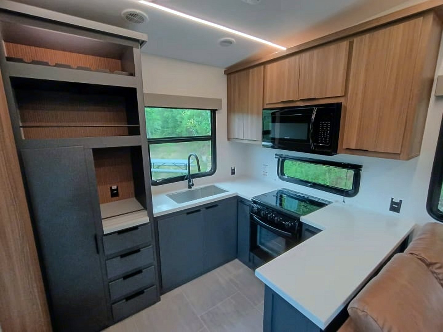 Camper rear kitchen with a sink, range, and microwave