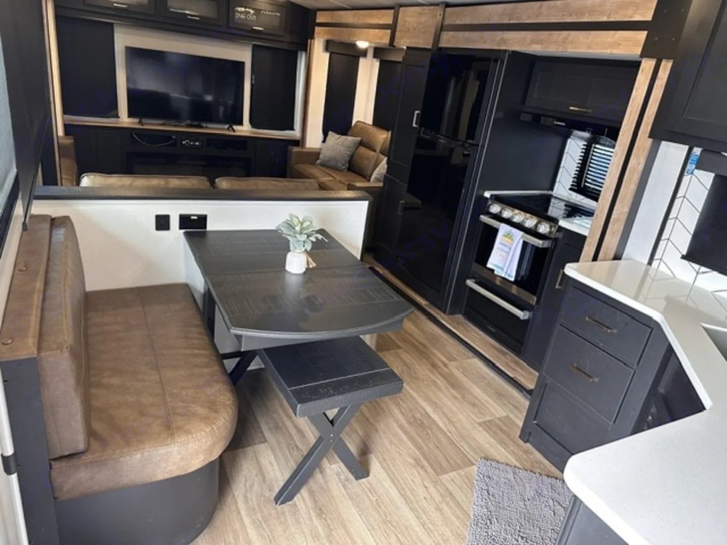 Camper dinette beside the range, oven and tall refrigerator