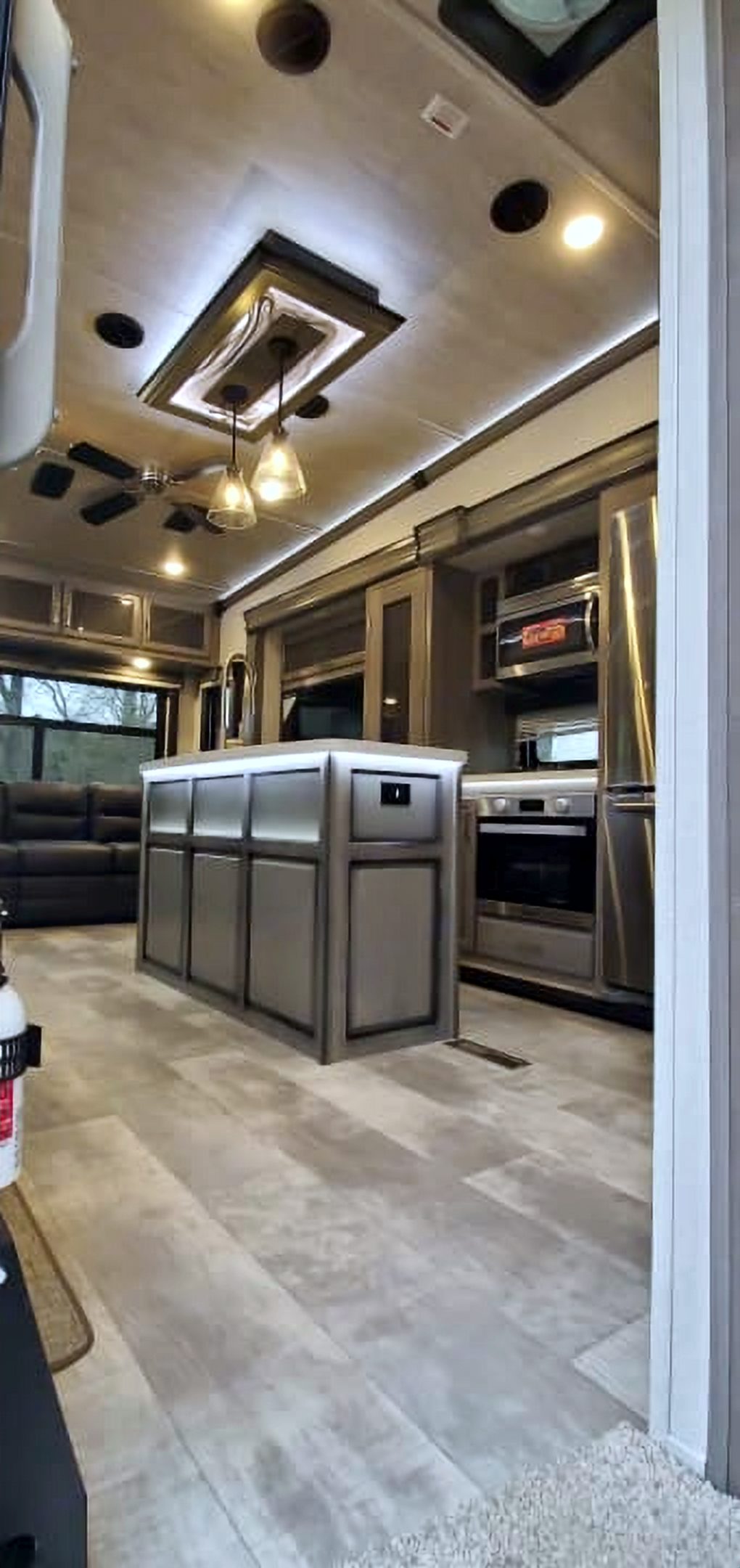 Camper interior looking past the kitchen island toward the living area