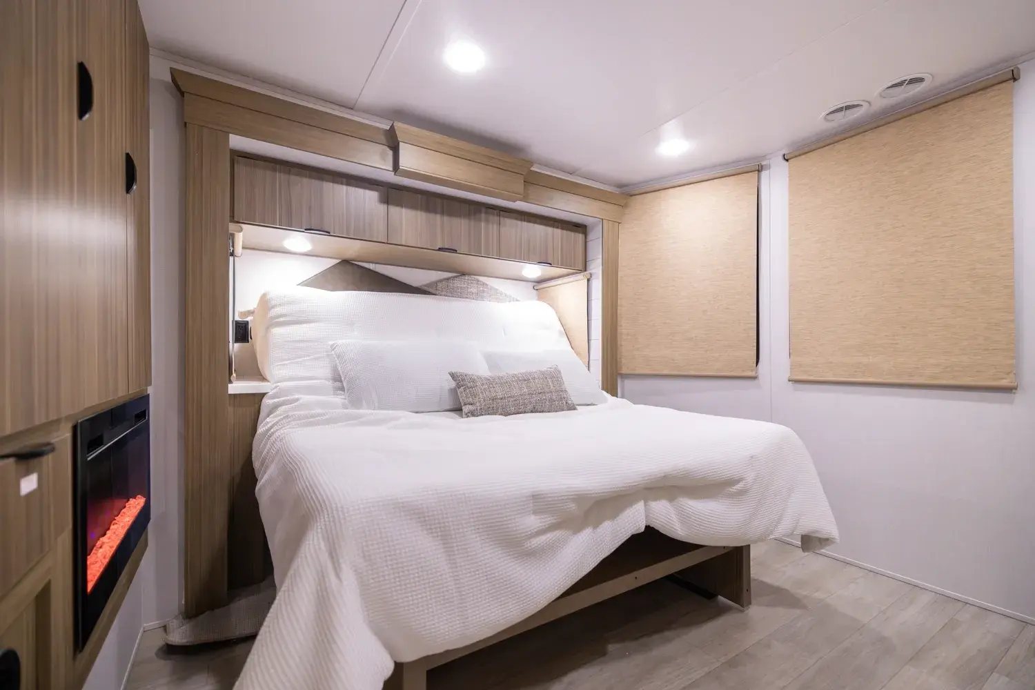 Camper front bedroom with a fireplace beside the bed
