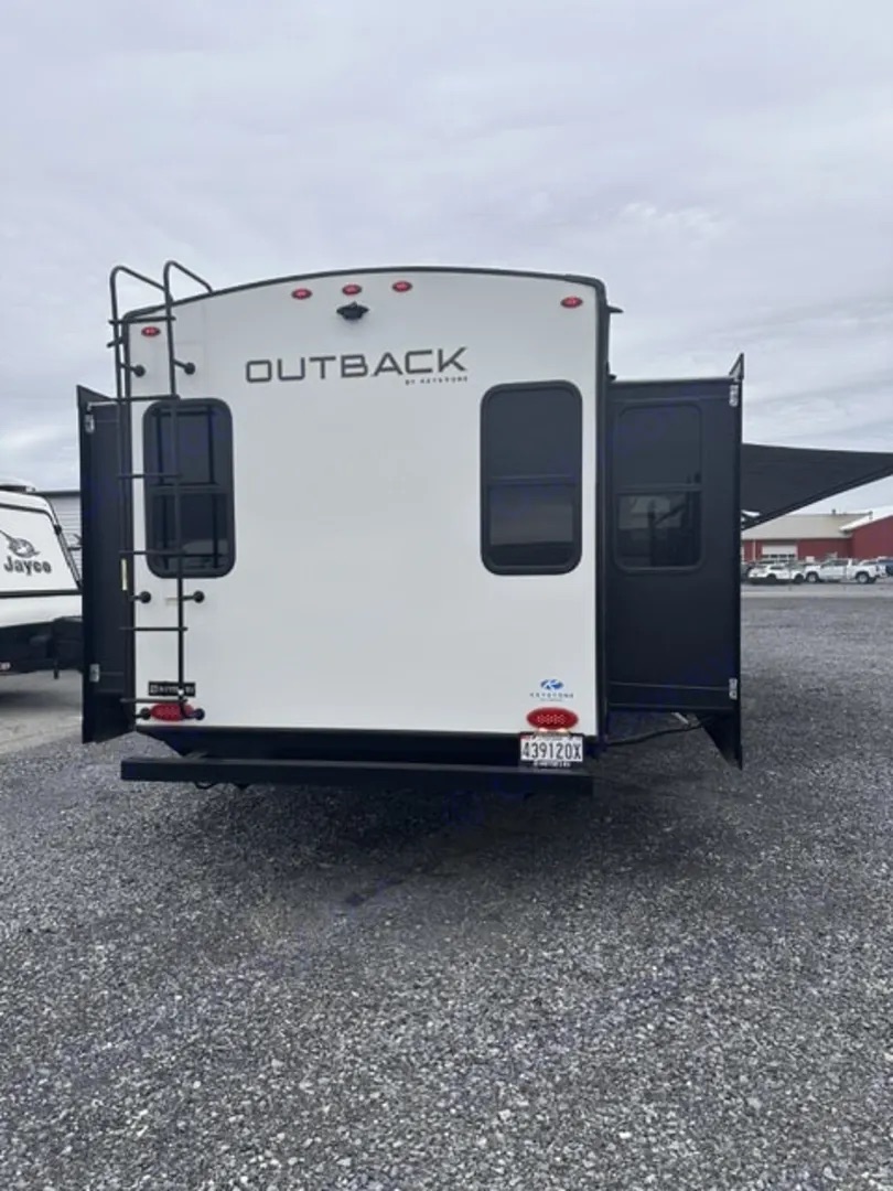 Rear view of a Keystone Outback travel trailer with rear ladder