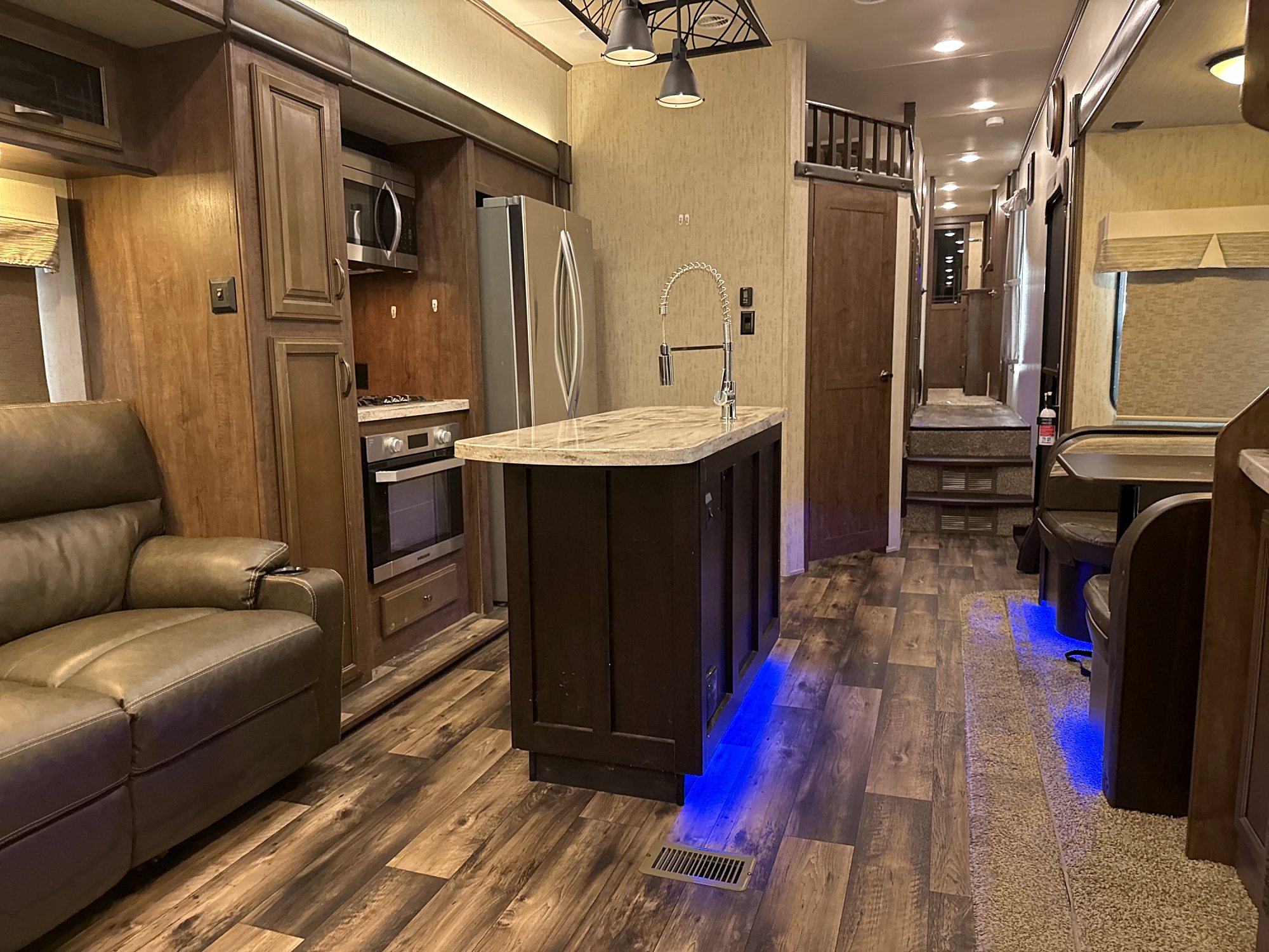 Camper interior looking past the kitchen island toward the front