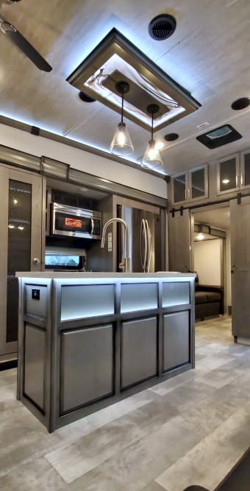 Camper kitchen island with lighted panels in front of the kitchen