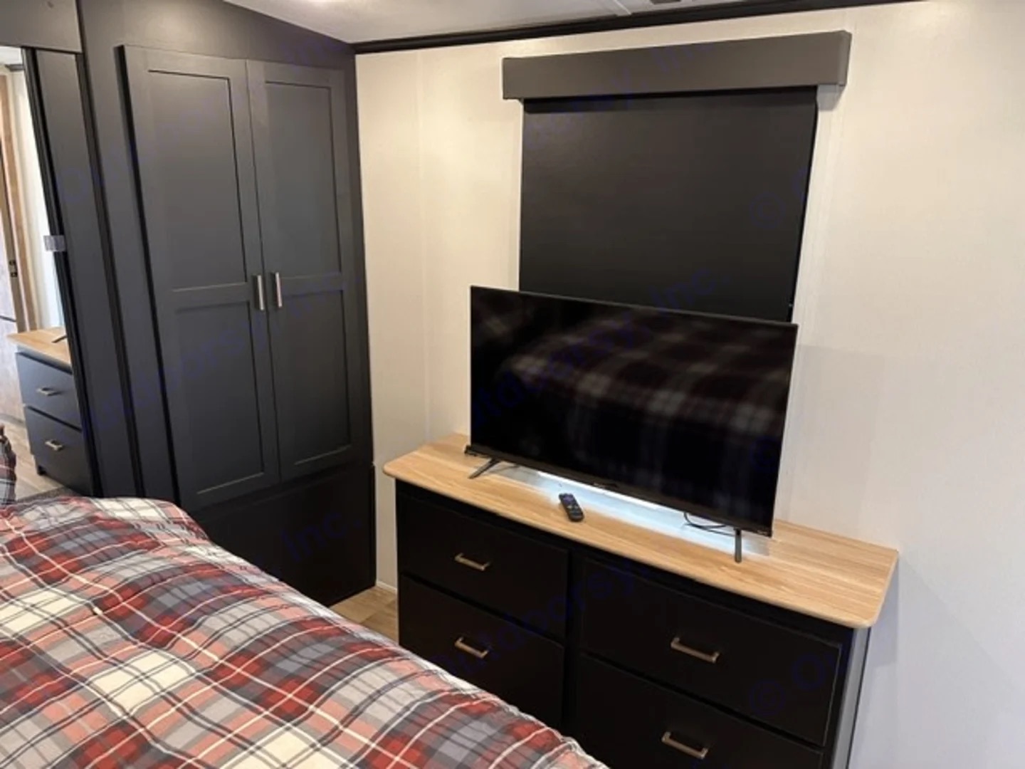 Camper bedroom dresser with a television and a closet
