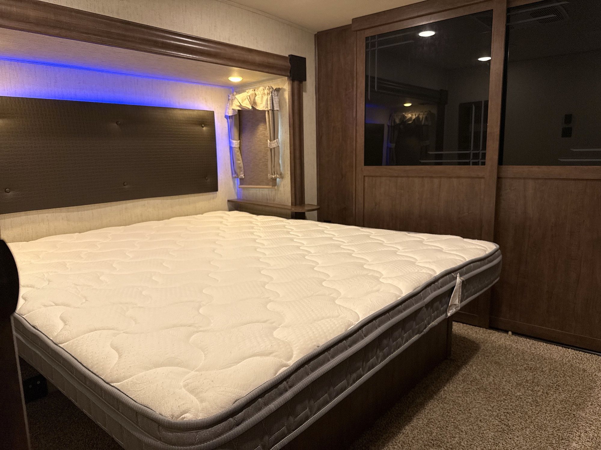 Camper front bedroom with a padded headboard