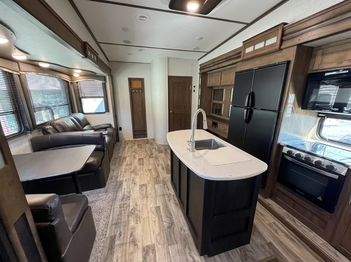 Open interior of the fifth-wheel with a kitchen island, dinette, and sofa