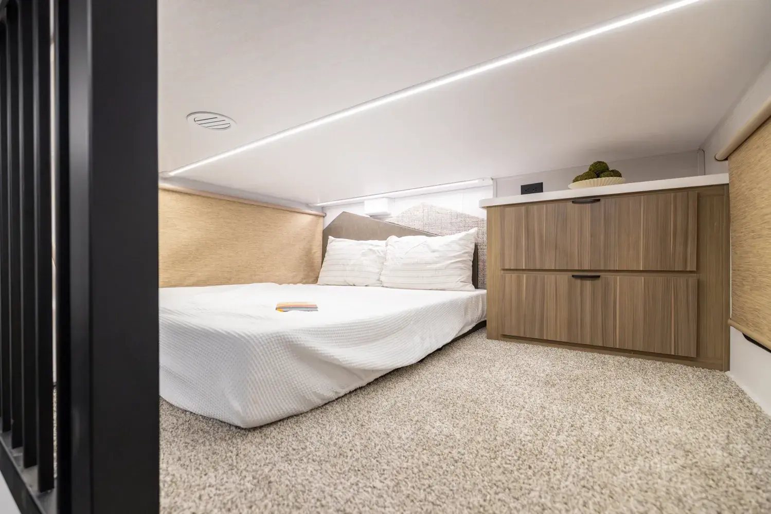 Camper rear loft with a queen mattress and a dresser