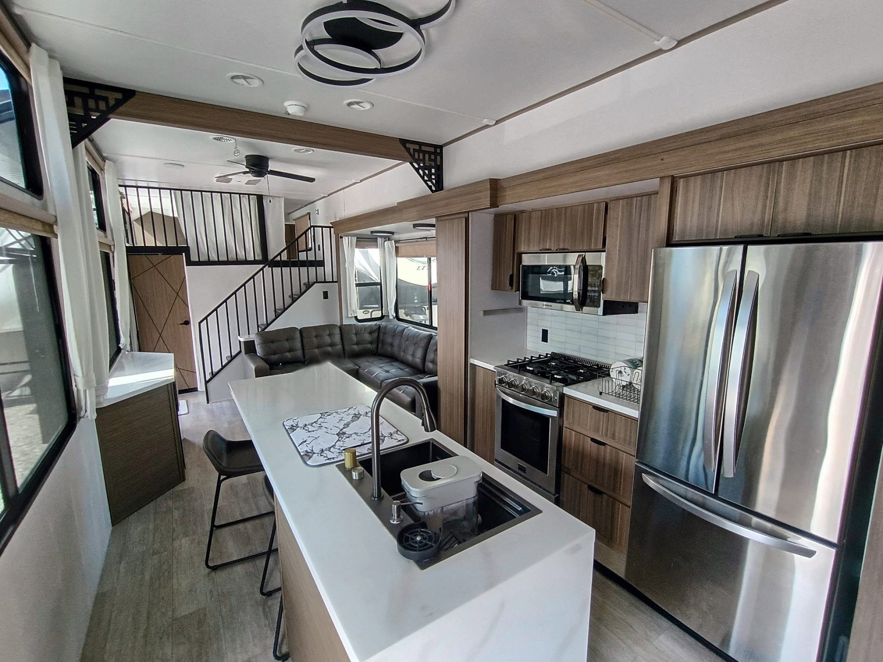 Camper kitchen island across from the range and a stainless refrigerator