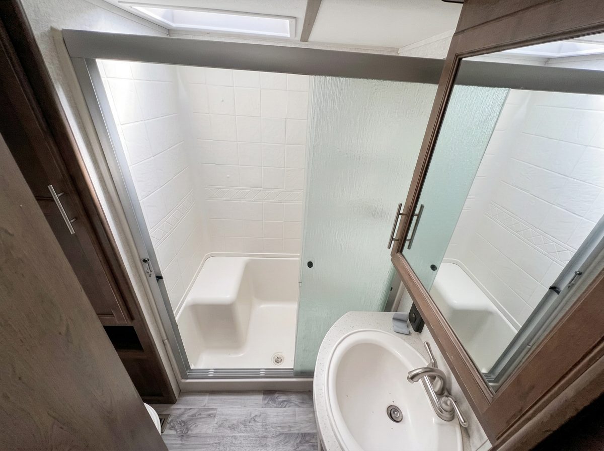 Full bathroom with a walk-in shower and skylight