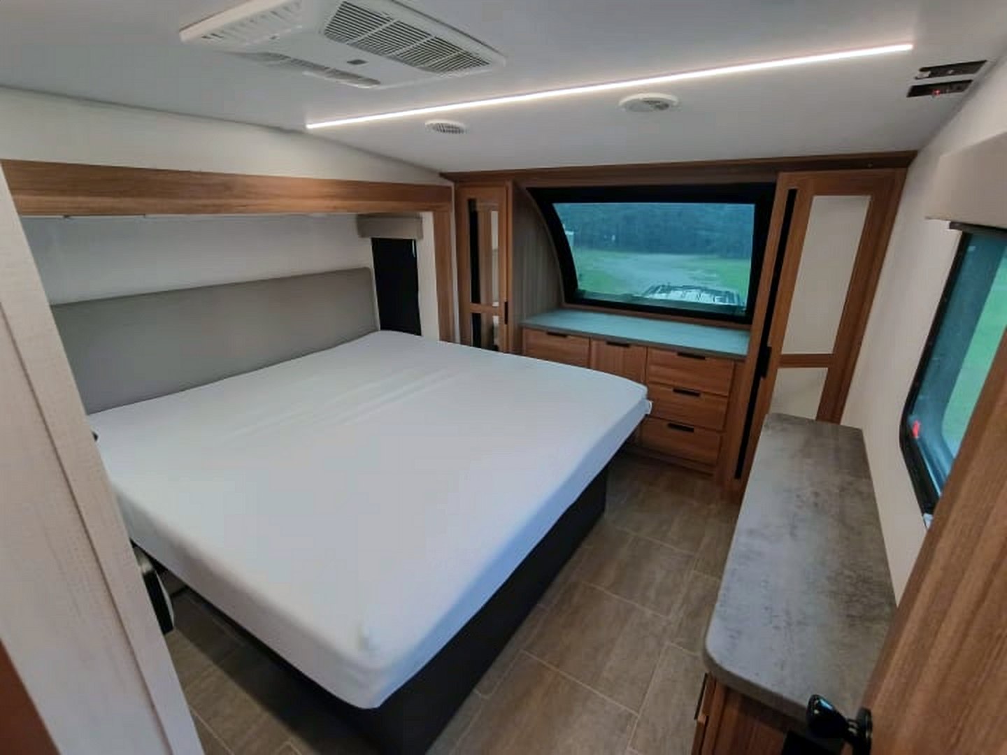 Camper front bedroom with drawers under a large front window