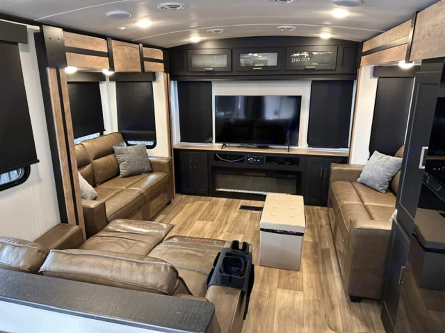 Camper rear living room with seating on both sides, fireplace and television