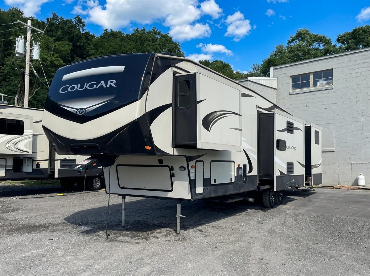 Exterior of a Keystone Cougar fifth-wheel camper with slide-outs, set up for temporary housing